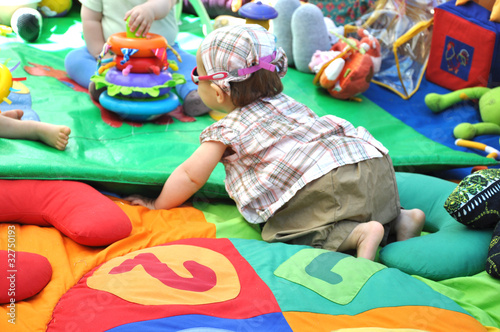 bébé fille qui joue sur son tapis d'éveil d'activité