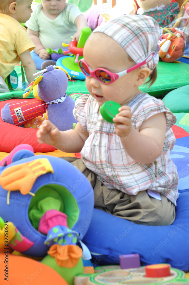 Obraz premium bébé fille qui s'éveille et s'amuse avec sur son tapis d'éveil