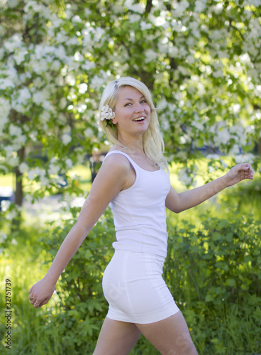 Beautiful joyful blonde walks in summer park © jura