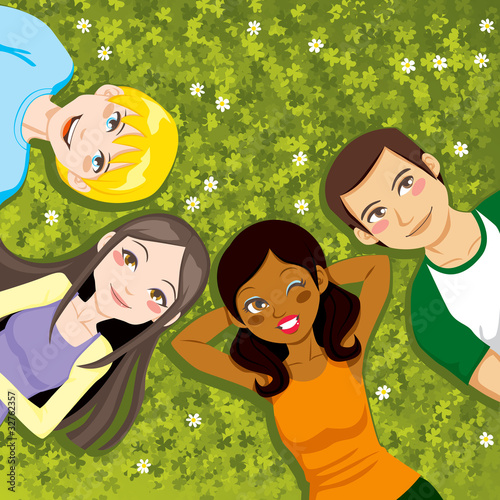 Four teenager friends resting in clover field
