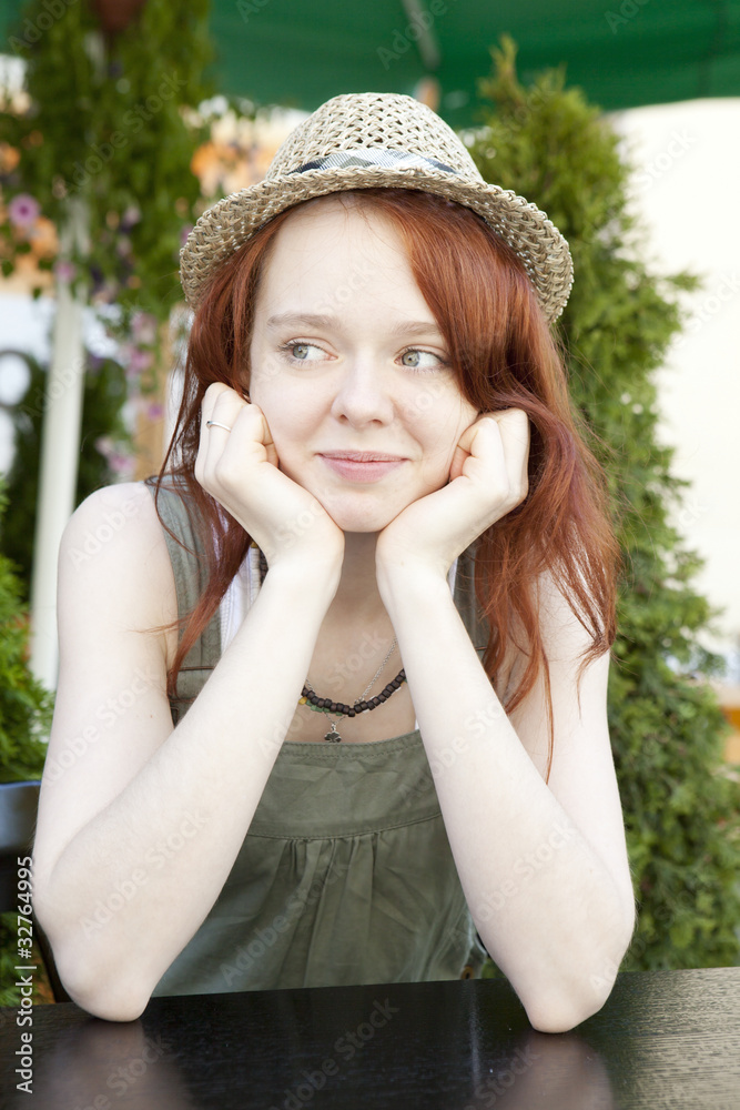pensive red hair woman wearing straw hat