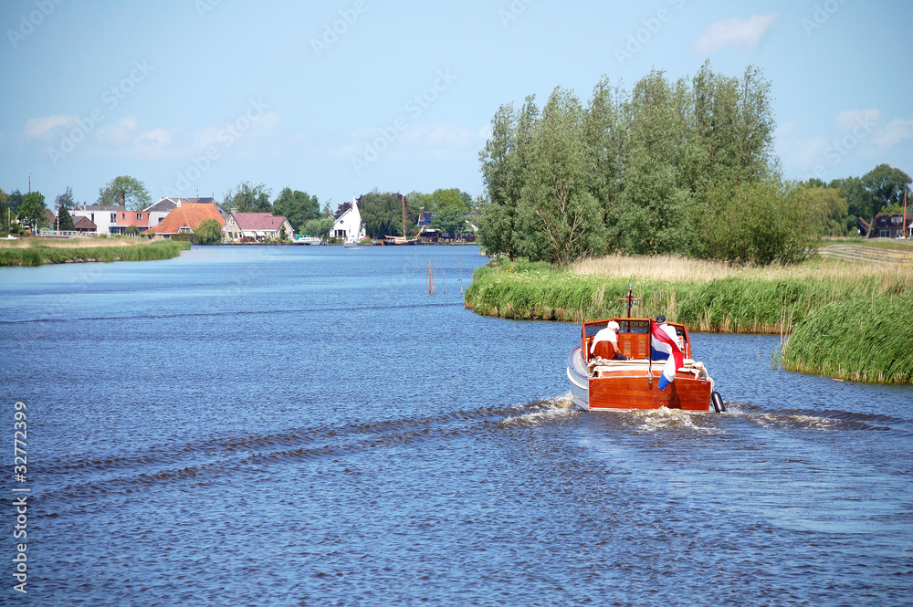 Fototapeta premium Kanal in Friesland mit Boot im Vordergrund