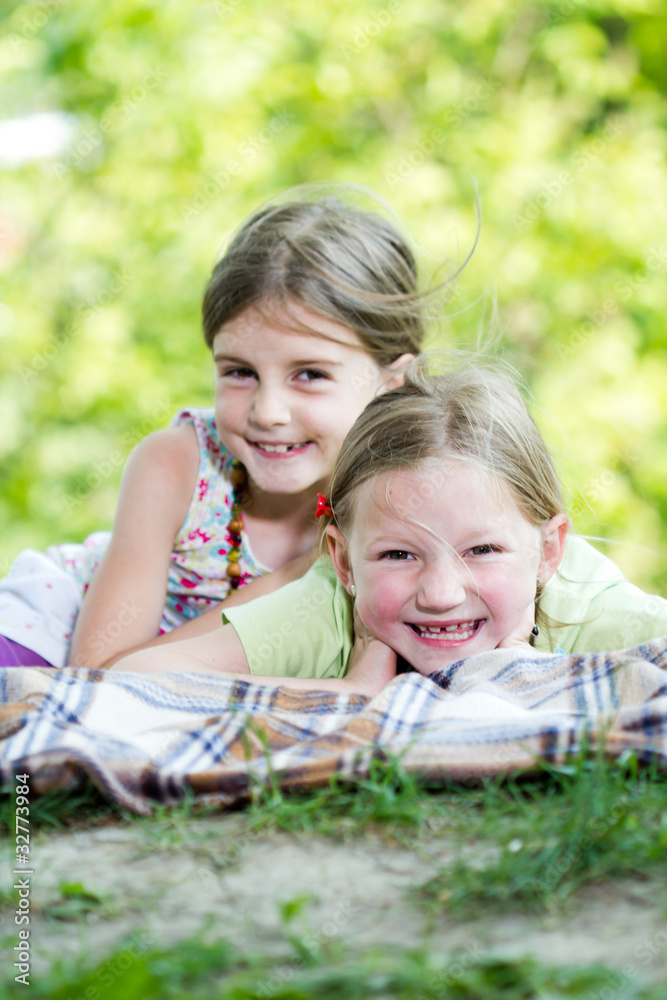 Portrait of two cute girls having rest in park on summer day Portrait of two cute girls having rest in park on summer day