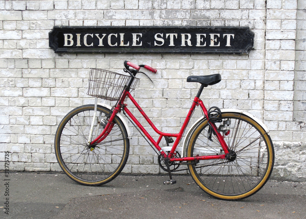 Bicycle Street sign with a red bicycle against wall Bicycle Street sign with a red bicycle against wall
