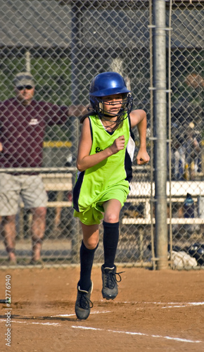 Young Girl Softball Player Running to First Base