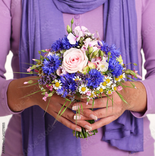 Female Hands Holding a Bunch of Flowers