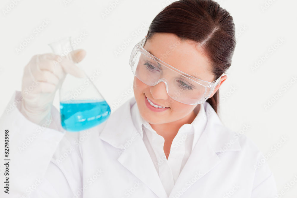 Good looking scientist holding a beaker in a laboratory Good looking scientist holding a beaker in a laboratory