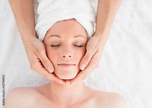 Closeup of a young pretty red-haired woman receiving a massage i