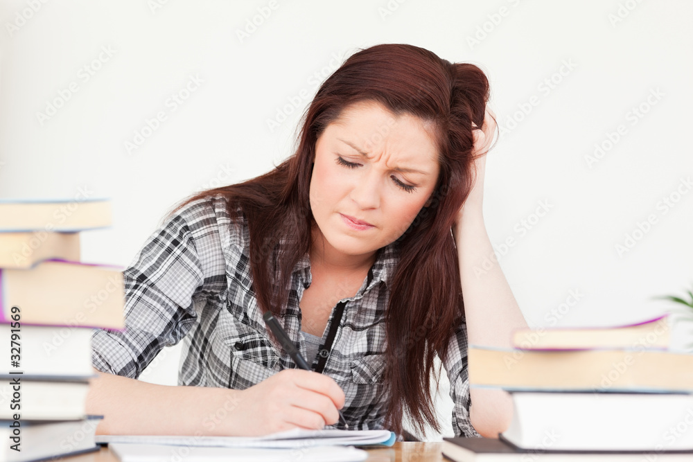 Beautiful red-haired girl being upset while studying for an exam Beautiful red-haired girl being upset while studying for an exam