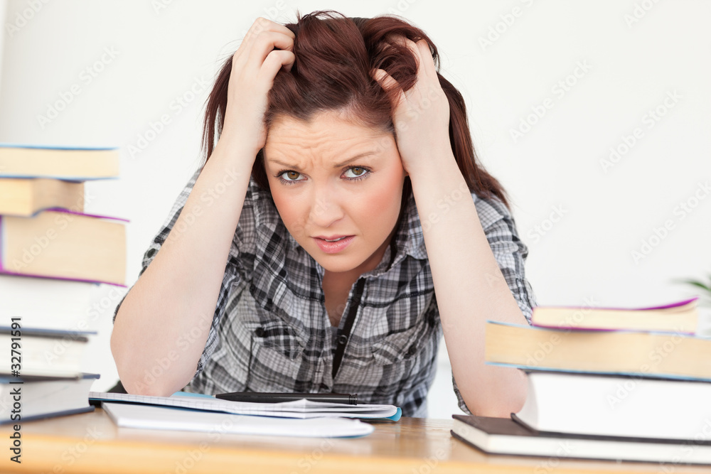 Beautiful red-haired female being upset while studying for an ex Beautiful red-haired female being upset while studying for an ex