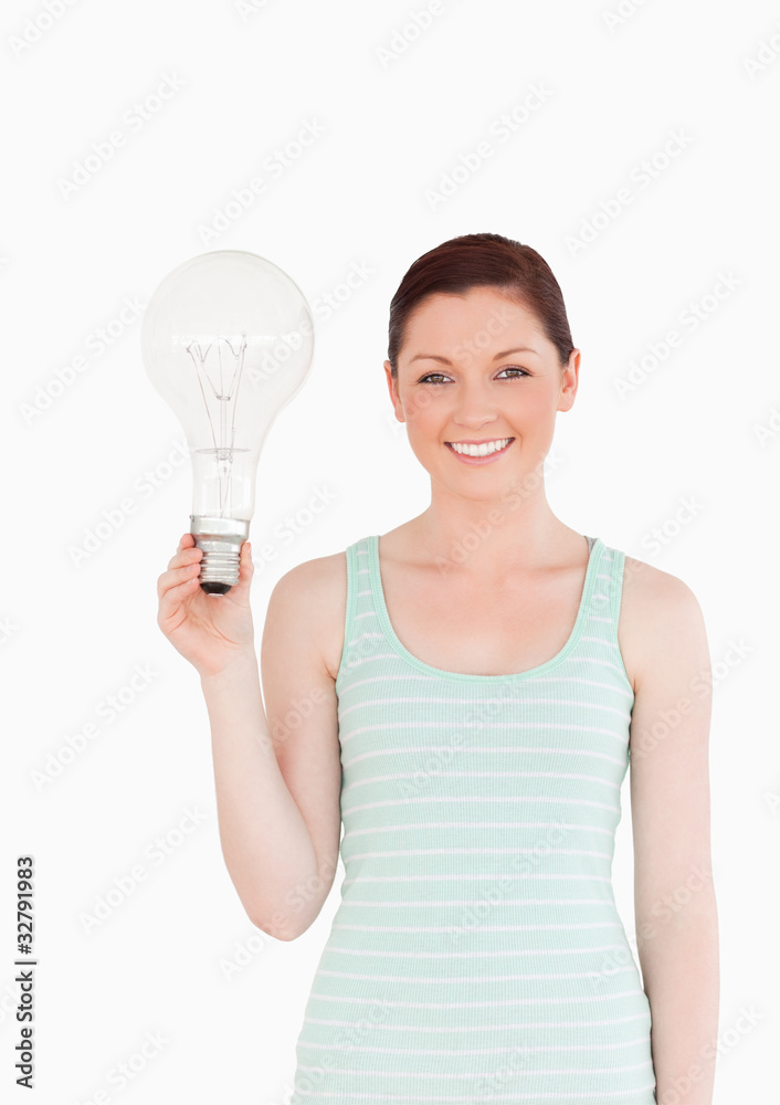 Gorgeous red-haired female holding a bulb while standing Gorgeous red-haired female holding a bulb while standing