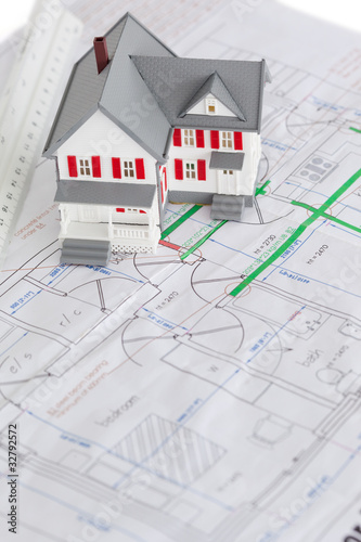 Close-up of toy house model and ruler on a plan