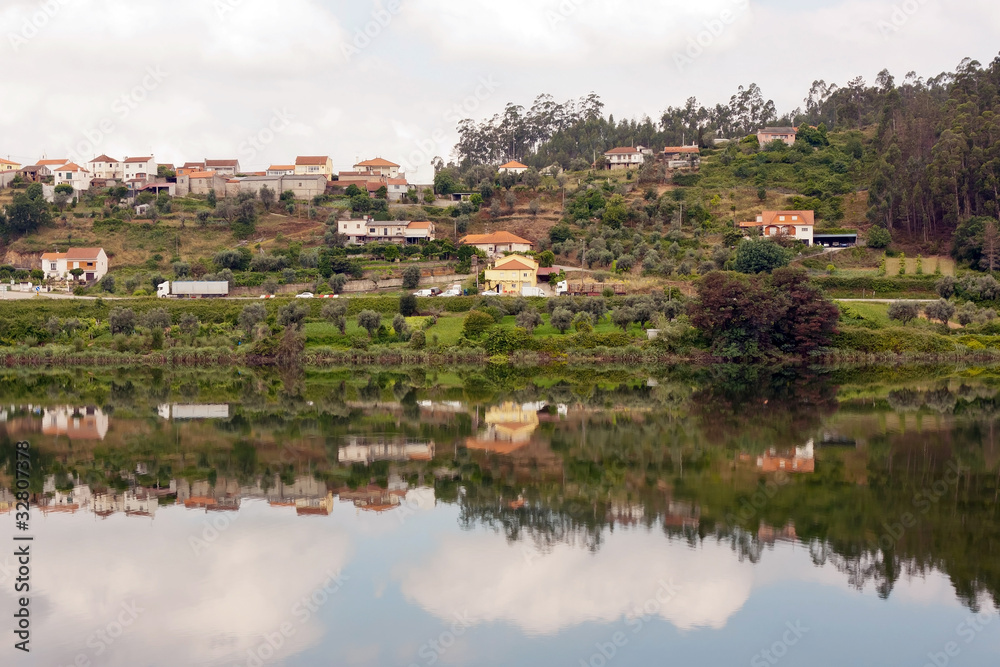 Landscape of a small village with its reflection in the river