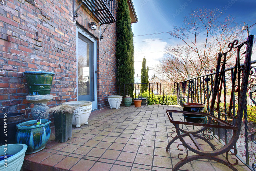 English brick hose deck with pots and iron chairs