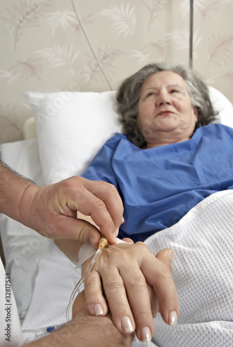 adult helping senior in hospital