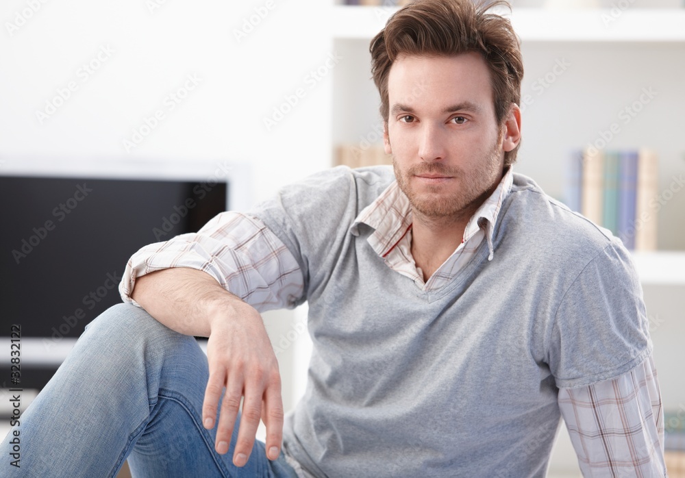 Casual man sitting on floor at home