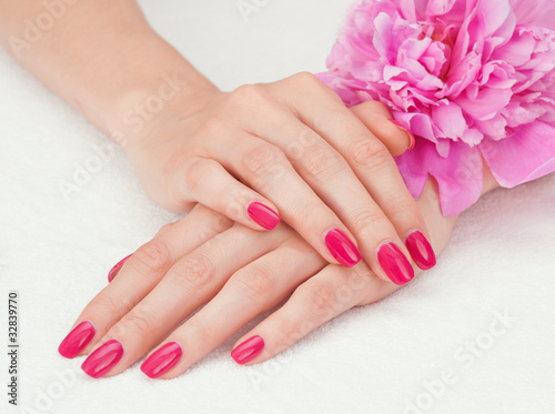 Woman beautiful hands with manicure and pink peony flower