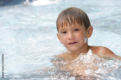 portrait of young boy swimming in pool