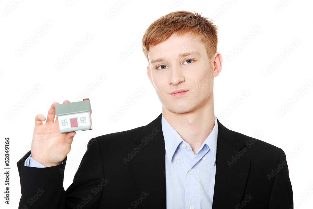 Young business man holding house model Young business man holding house model