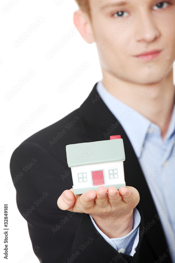 Young business man holding house model Young business man holding house model