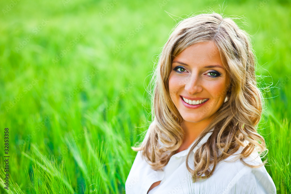 Blond woman portrait outdoor on green field Blond woman portrait outdoor on green field