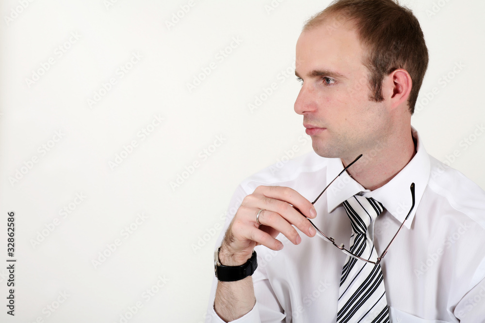 Young businessman is thinking with glasses Young businessman is thinking with glasses