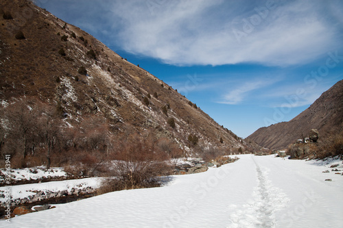 Volumetric landscape of mountains in early spring. Snowy trail
