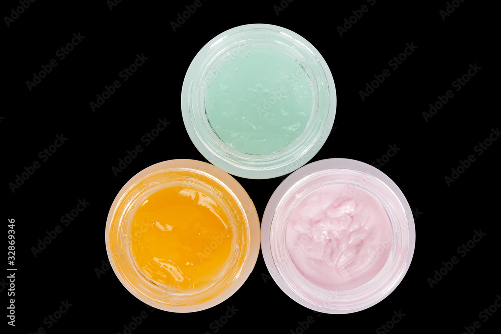 Three pots of skin care colored lotion. Three pots of skin care colored lotion.