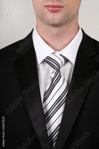 Portrait of businessman wearing a black suit and black white tie