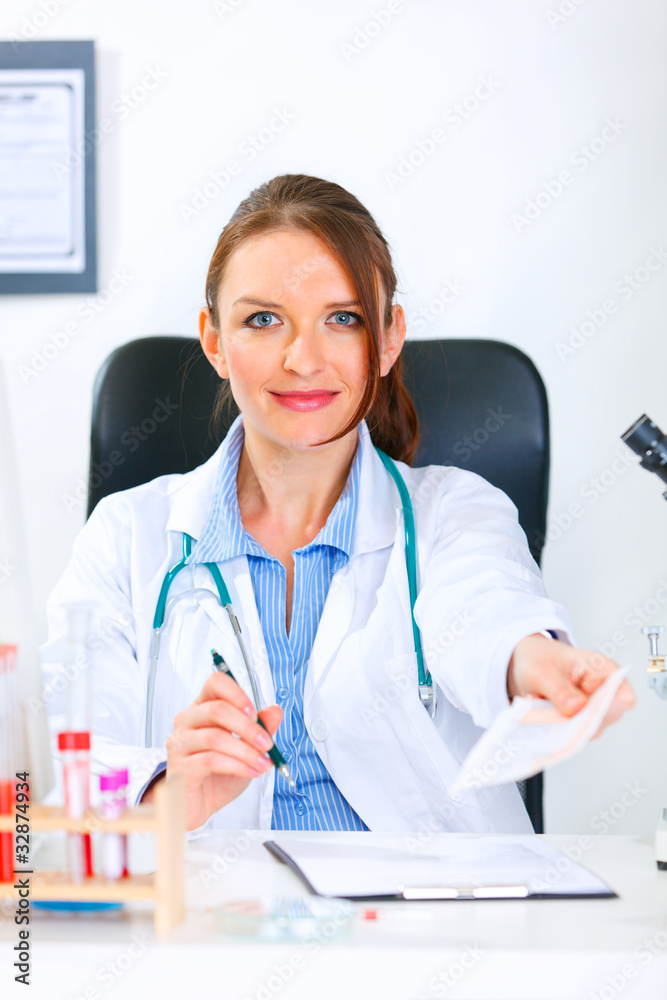 Doctor woman sitting at table and giving medical prescription. Doctor woman sitting at table and giving medical prescription.