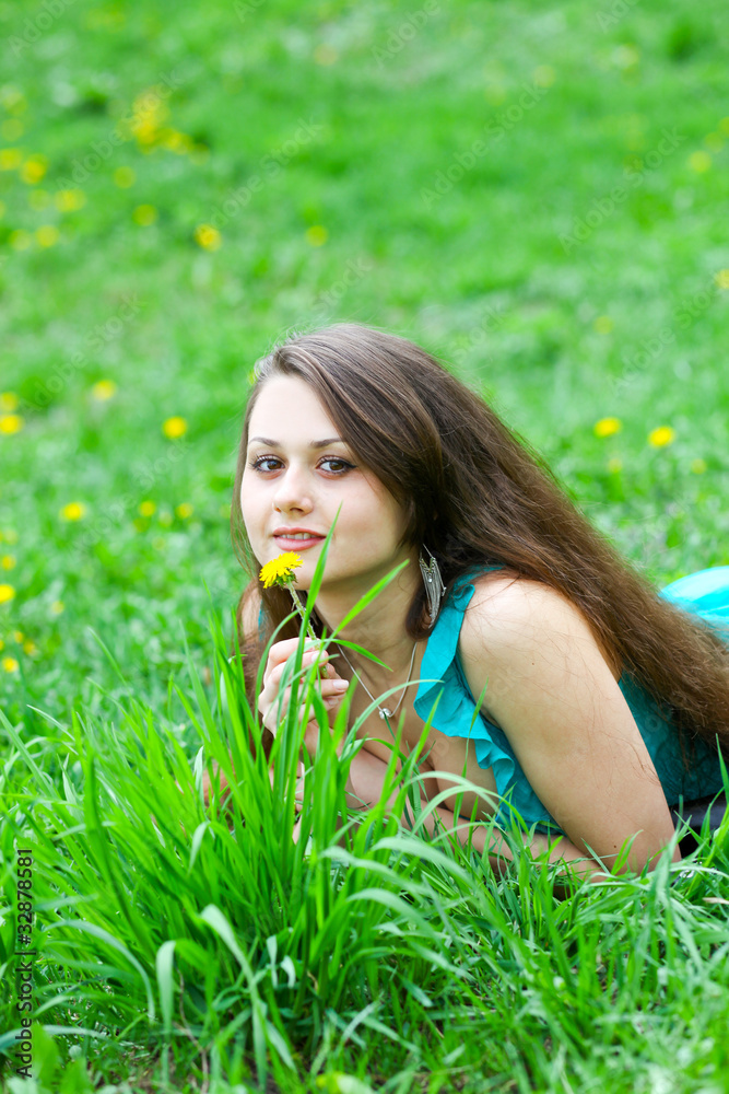Pretty young girl with dandelion relaxing on the lawn Pretty young girl with dandelion relaxing on the lawn
