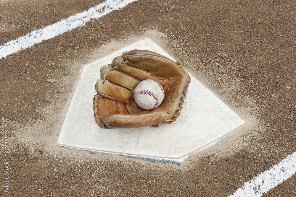 Fotografie A baseball glove on homeplate
