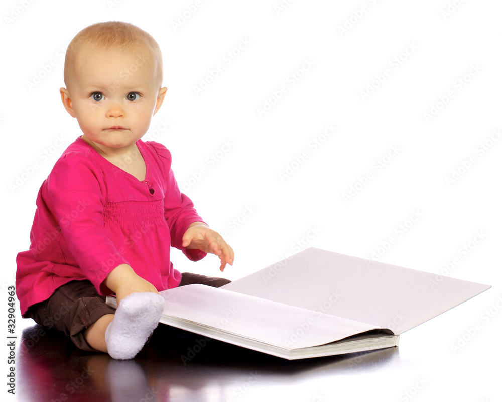 Infant baby girl enjoying and discovering books Infant baby girl enjoying and discovering books