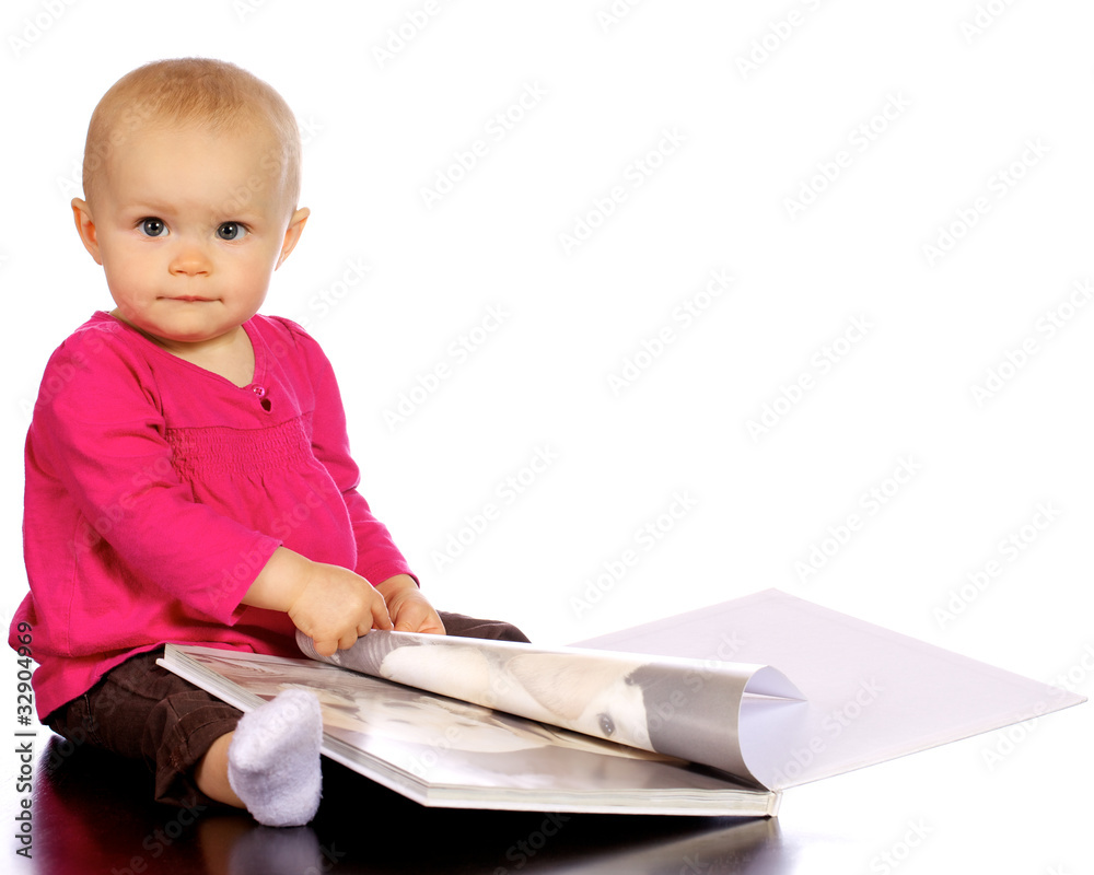 Infant baby girl enjoying and discovering books Infant baby girl enjoying and discovering books