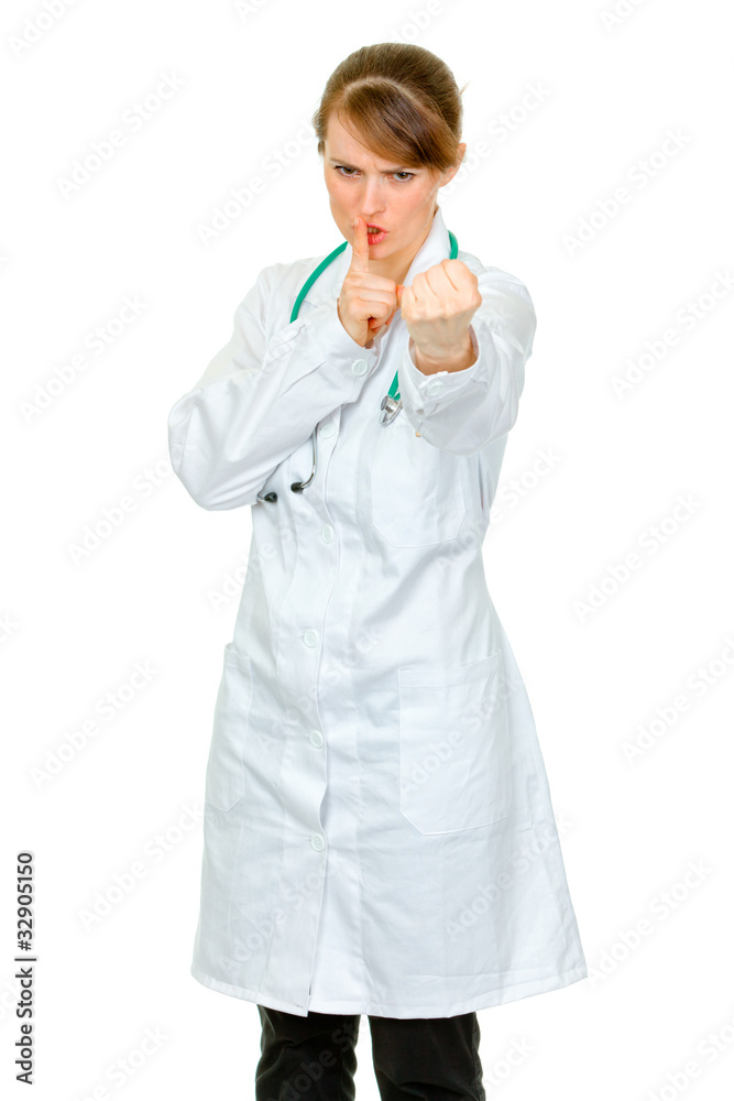 Angry doctor woman with finger at mouth and threaten with fist Angry doctor woman with finger at mouth and threaten with fist
