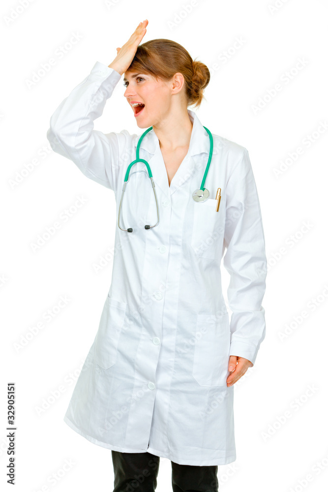 Surprised medical doctor woman striking her forehead Surprised medical doctor woman striking her forehead