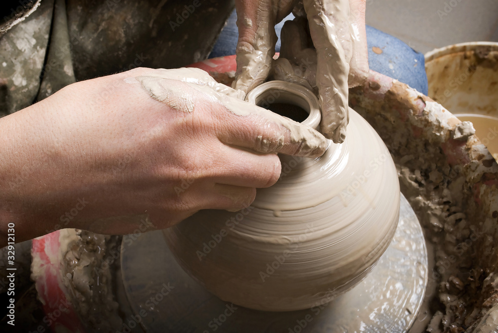 The hands of a potter, creating an earthen jar on the circle The hands of a potter, creating an earthen jar on the circle