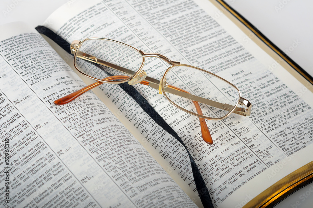 open bible with glasses isolated on white background open bible with glasses isolated on white background