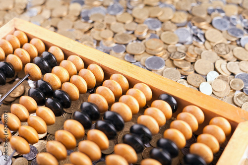 Accounting abacus and heap of coins