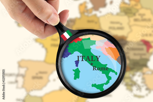 Magnifying glass over a map of Italy