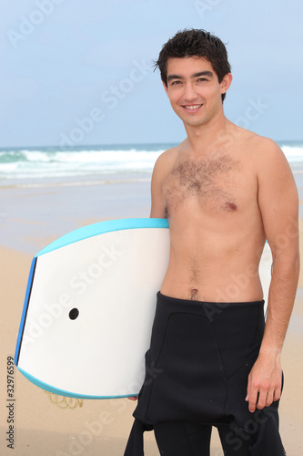young man on the beach is going to do bodyboard