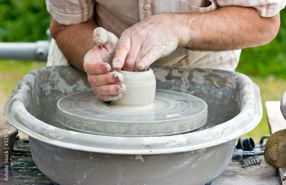 Close-up of potter's hands turning clay on a potter's wheel. Close-up of potter's hands turning clay on a potter's wheel.