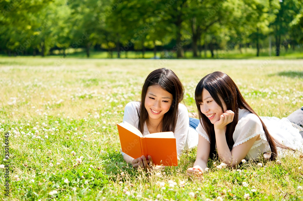 beautiful asian women reading a book in the park