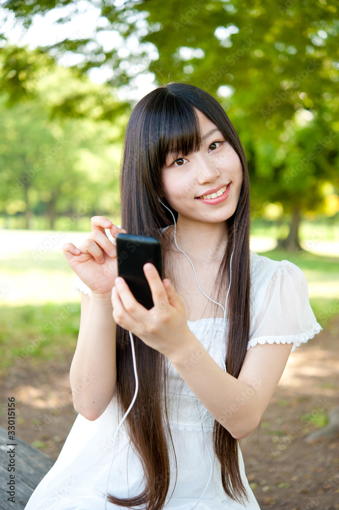 beautiful asian woman using a smartphone in the park beautiful asian woman using a smartphone in the park