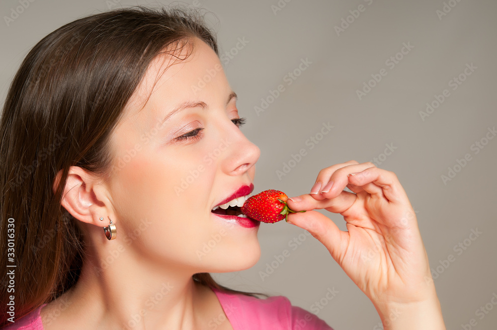 Beautiful girl takes a bite of strawberry Beautiful girl takes a bite of strawberry