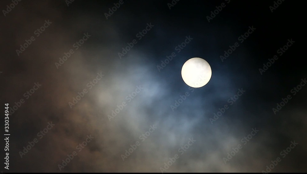 Full moon moving in and out clouds with birds flying