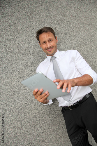 Smiling salesman using electronic tablet