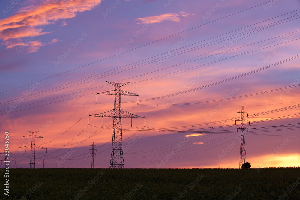 Transmission towers on the hill at pink sunset