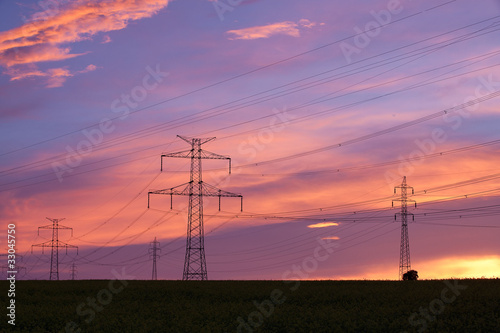 Transmission towers on the hill at pink sunset © Radomir Rezny