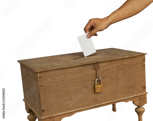 A man's hand putting an envelope in the slot of a box photo